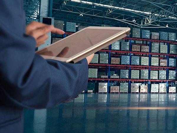 Warehouse worker with tablet tracking shipments